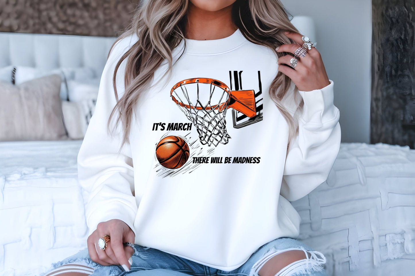 A woman in an adult size white Its March sweatshirt by DB Custom Creations, featuring a basketball graphic and hoop with the text ITS MARCH THERE WILL BE MADNESS, pairs it with ripped denim shorts and rings—ideal for showing off your DTF transfer style.