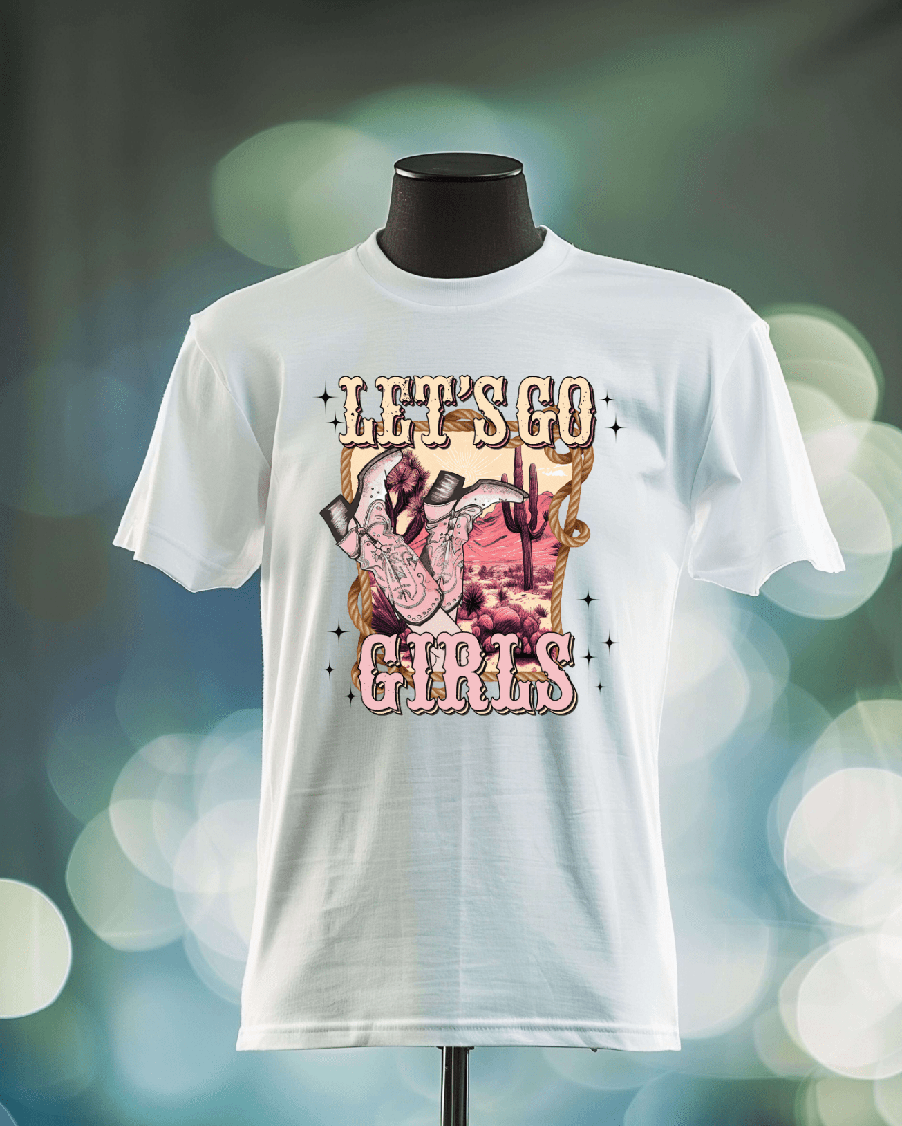A white T-shirt from DB Custom Creations, called Lets Go Girls, features a graphic of a hand doing the rock-on gesture, cacti, and a desert scene, with LETS GO GIRLS in bold decorative letters above and below.