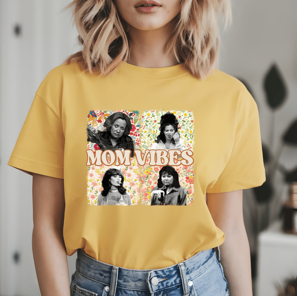 A woman wears the Mom Vibes shirt by DB Custom Creations, featuring a yellow floral collage and black-and-white photos of women with “MOM VIBES” text on the front, made with vibrant DTF printing for lasting quality.