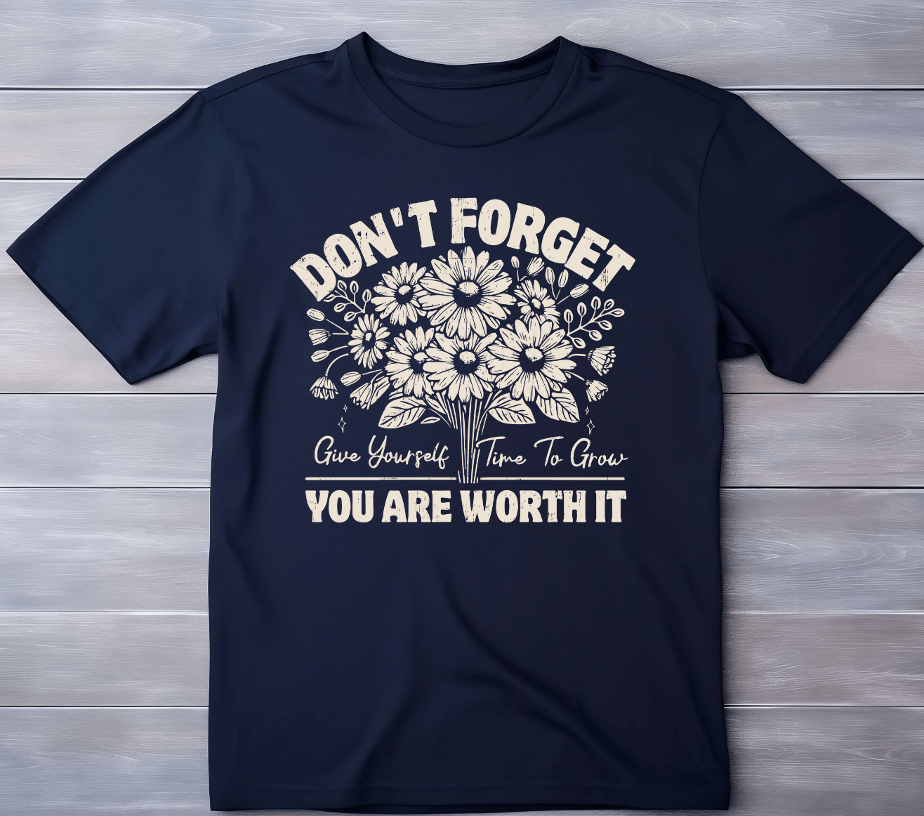 The Worth it T-shirt by DB Custom Creations features a navy blue color, floral design, and the words: DONT FORGET Give Yourself Time To Grow YOU ARE WORTH IT in beige 11-inch DTF print, shown flat on a light wood surface.
