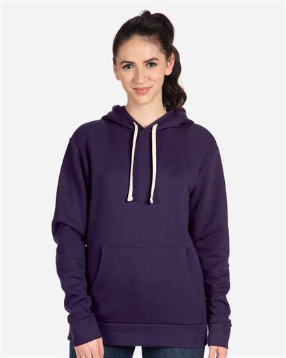 A person with long brown hair in a ponytail wears a Next Level 9303 dark purple cotton-polyester hoodie with white drawstrings and a front pocket, standing against a plain light background.