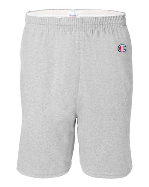 Champion 8187 athletic shorts in light gray feature an elastic waistband and an embroidered logo on the left thigh. Made from 100% cotton, they offer a simple, comfortable design with no visible pockets or patterns.