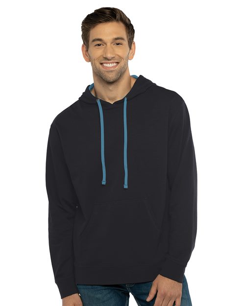 A smiling man faces the camera in a Next Level 9301 black cotton-polyester hoodie with blue drawstrings and blue jeans, set against a plain white background.