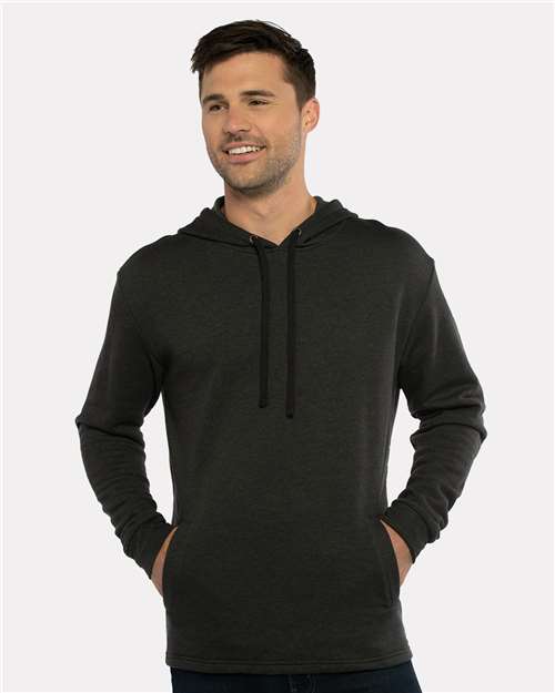 A man stands smiling with his hands in the front pocket, wearing the Next Level 9300 dark gray cotton-polyester fleece hoodie against a plain light background—a nod to sustainable style.