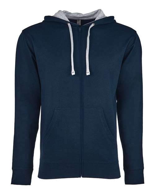 The Next Level 9601 hoodie features a dark blue cotton-polyester blend, light gray hood lining, white drawstrings, two front pockets, and a tear-away label. Shown on a plain white background.