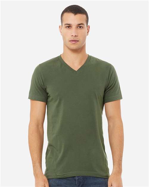 A man faces forward in a plain olive green BELLA + CANVAS 3005 unisex V-neck short-sleeve T-shirt made from Airlume combed cotton and blue jeans, standing against a light gray background.