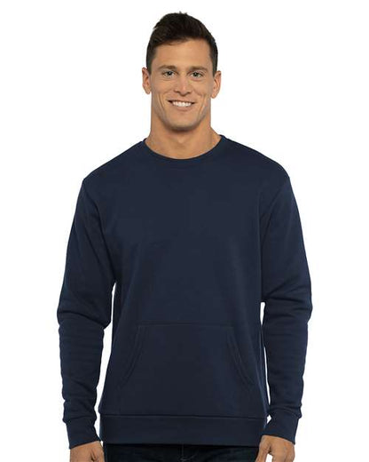 A man with short brown hair smiles while wearing the Next Level 9001 unisex fit navy blue crewneck sweatshirt, made from cotton/polyester fleece with a front pocket, standing against a white background.