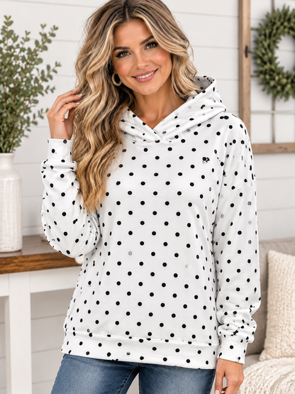 A woman wearing a lightweight, white Polka Dot Hooded Sweatshirt with a black polka dot pattern.