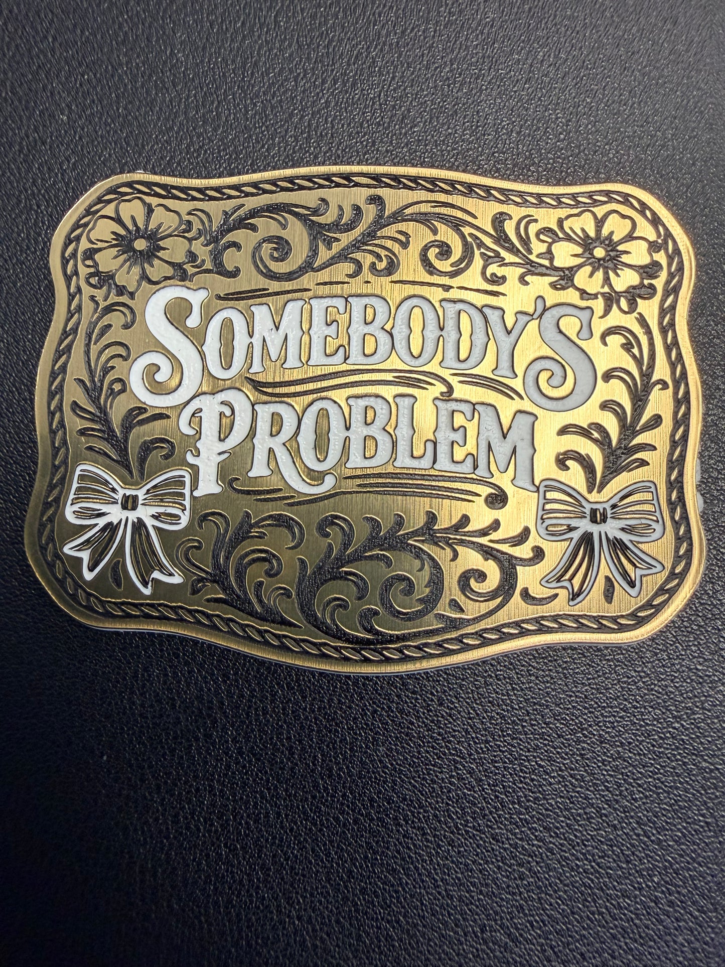 DB Custom Creations' Custom Laser Engraved Tri Layered Acrylic Patch features floral patterns, two bows, and "Somebodys Problem" text. Crafted like luxury patches, it stands out against a textured black background. Perfect for hats.