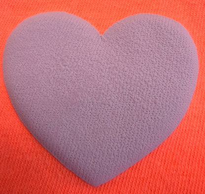 A textured purple heart-shaped transfer from DB Custom Creations’ Custom Puff Transfers for T-Shirts and Apparel rests on a bright orange, ribbed fabric background.