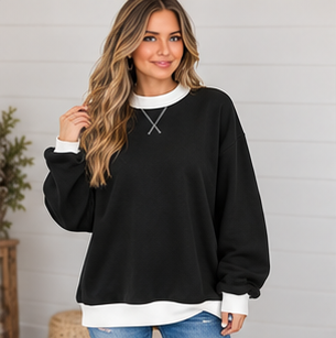 A person wearing a black DB Custom Creations Oversized Mock Neck with white trim at the neck, hem, and cuffs, ideal for everyday wear.