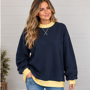 A woman wearing a navy blue DB Custom Creations Oversized Mock Neck sweatshirt with yellow trim at the neck, cuffs, and hem, crafted from premium fabric.
