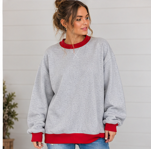 A person wears a light gray Oversized Mock Neck sweatshirt featuring a red collar, cuffs, and hem.