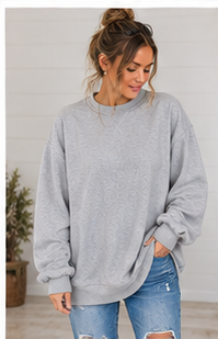 A woman wears a DB Custom Creations Oversized Mock Neck in premium fabric paired with blue distressed jeans for everyday wear.