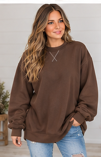 A woman wears a brown DB Custom Creations Oversized Mock Neck sweatshirt with stitched detailing at the neckline paired with blue distressed jeans.