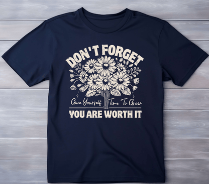 The Worth it T-shirt by DB Custom Creations features a navy blue color, floral design, and the words: DONT FORGET Give Yourself Time To Grow YOU ARE WORTH IT in beige 11-inch DTF print, shown flat on a light wood surface.